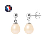 Une paire de Boucle d'Oreilles MINÉA de Perlinea, en or blanc avec des perles de culture roses, est présentée sur un fond blanc. Le logo rond de l'Artisanat Bijouterie Française en bleu, rouge et blanc est visible dans le coin supérieur gauche.