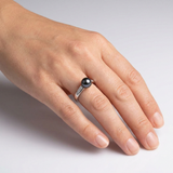 Bague or blanc 9 carats et diamants avec perle de Tahiti noire portée à l'annulaire.
