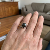 Bague or blanc 9 carats portée à la main, ornée d'une perle de culture noire de Tahiti.