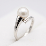 Bague or blanc 9 carats sertie d'une perle de culture blanche, design contourné élégant.