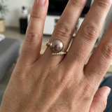 Bague en or jaune 9 carats portée, perle de Tahiti grise et diamants en serti pavé.