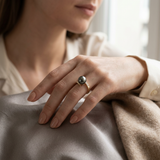 Bague en or jaune 9 carats avec perle de Tahiti noire et diamants, portée à la main.