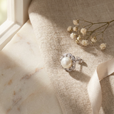 Boucle d'oreille argent 925 ornée d'une perle blanche et d'un contour pavé de zircons.