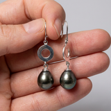 Boucles d'oreilles argent 925 DAISY circle avec perles noires, présentées dans une main.