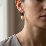 Boucles d'oreilles argent 925 et perles de culture roses portées à l'oreille.