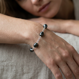 Bracelet argent 925 porté au poignet avec 5 perles de Tahiti noires 9-10mm sur chaîne.
