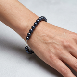 Bracelet en argent 925 et perles noires 8/9 mm porté au poignet, fermoir mousqueton argenté.