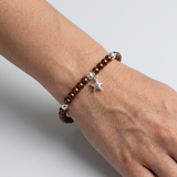 Bracelet perles chocolat argent 925 avec charm étoile porté au poignet.