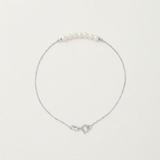 Bracelet en or blanc 9 carats avec cinq perles blanches alignées sur chaîne fine.