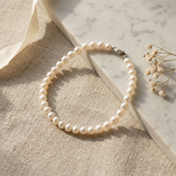 Bracelet en or blanc 9 carats et perles blanches avec fermoir mousqueton argenté.