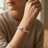 Bracelet perles blanches 6/7 mm en argent 925 avec fermoir anneau marin, porté au poignet.