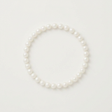 Bracelet en perles d'eau douce blanches sur argent 925, posé à plat sur fond neutre.