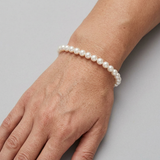Bracelet perles d'eau douce blanches en argent 925 porté au poignet.