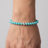 Bracelet perles d'eau douce bleu turquoise et argent 925 porté au poignet.
