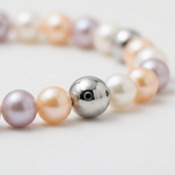 Gros plan sur le fermoir boule en argent 925 d'un bracelet perles d'eau douce pastel.