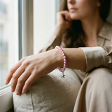 Bracelet perles d'eau douce roses fuchsia en argent 925 avec charm étoile, porté au poignet.
