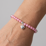 Bracelet perles roses fushia argent 925 avec charm cœur porté au poignet.