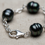 Gros plan sur le fermoir mousqueton argenté du bracelet perles de Tahiti 9-10mm en argent 925.