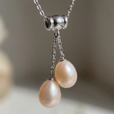 Collier toi et moi en argent 925 avec deux perles de culture roses suspendues.
