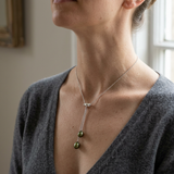 Collier toi et moi en argent 925 avec deux perles de culture vert intense, porté au cou.