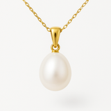 Pendentif en or jaune 9 carats avec perle de culture blanche ovale sur chaîne fine.