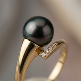 Bague or jaune 9 carats ornée d'une perle noire de Tahiti et trois diamants sertis.