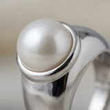 Gros plan sur la perle de culture blanche sertie en argent 925 de la bague Opaline.