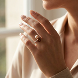 Bague duo en or blanc 9 carats avec perles de culture rose et chocolat portée à l'annulaire.