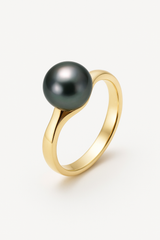 Bague or jaune 9 carats sertie d'une perle de Tahiti noire ronde sur fond neutre.