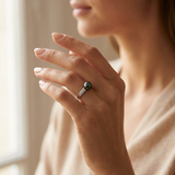 Bague or blanc diamants et perle de Tahiti noire portée à l'annulaire.