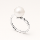 Bague or blanc 9 carats avec perle de culture blanche ronde et diamants sur anneau fin.