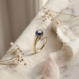 Bague en or jaune 9 carats sertie d'une perle noire et de petits diamants.