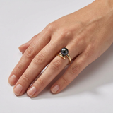 Bague en or jaune 9 carats ornée d'une perle de culture noire de Tahiti, portée à l'annulaire.