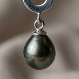 Gros plan sur une boucle d'oreille argent 925 avec perle noire nacrée baroque en pendentif.