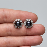 Boucles d'oreilles argent 925 à perles noires de Tahiti serties dans un entourage feuillagé pavé.