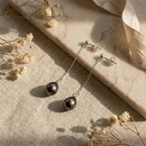 Boucles d'oreilles pendantes argent 925 et perles de Tahiti grises sur marbre.