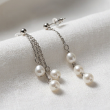 Boucles d'oreilles pendantes or blanc 9 carats, trois perles de culture blanches en cascade sur chaînes.