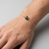 Bracelet argent 925 et perle noire de Tahiti porté au poignet.