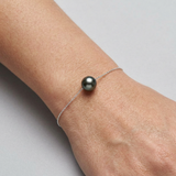Bracelet argent 925 et perle de culture noire de Tahiti porté au poignet.