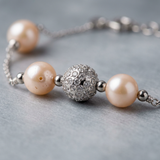 Bracelet argent 925 avec perles de culture roses et bille pavée de cristaux.