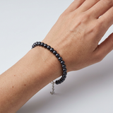 Bracelet en argent 925 et perles noires 6/7 mm porté au poignet, fermoir réglable argenté.