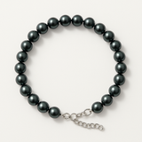 Bracelet en argent 925 orné de perles noires rondes avec fermoir réglable en chaîne.