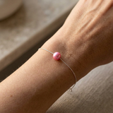 Bracelet chaîne argent 925 avec perle de culture rose fushia porté au poignet.