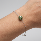 Bracelet chaîne forçat argent 925 avec perle de culture verte intense porté au poignet.