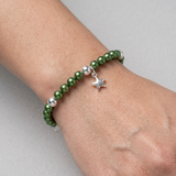 Bracelet étoile en argent 925 avec perles d'eau douce vertes rondes porté au poignet.