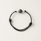 Bracelet homme en coton ciré noir avec perle de Tahiti et perles d'argent, ajustable par nœuds.