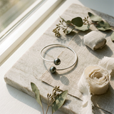 Bracelet jonc en argent 925 ouvert, orné de deux perles noires de Tahiti aux extrémités.
