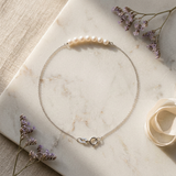 Bracelet or blanc 9 carats avec rangée de perles blanches et chaîne fine, fermoir anneau.
