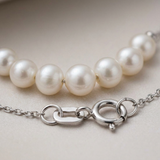 Gros plan sur le fermoir et les perles blanches du bracelet en or blanc 9 carats.