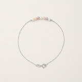 Bracelet or blanc 9 carats avec perles multicolores roses, blanches et mauves sur chaîne fine.